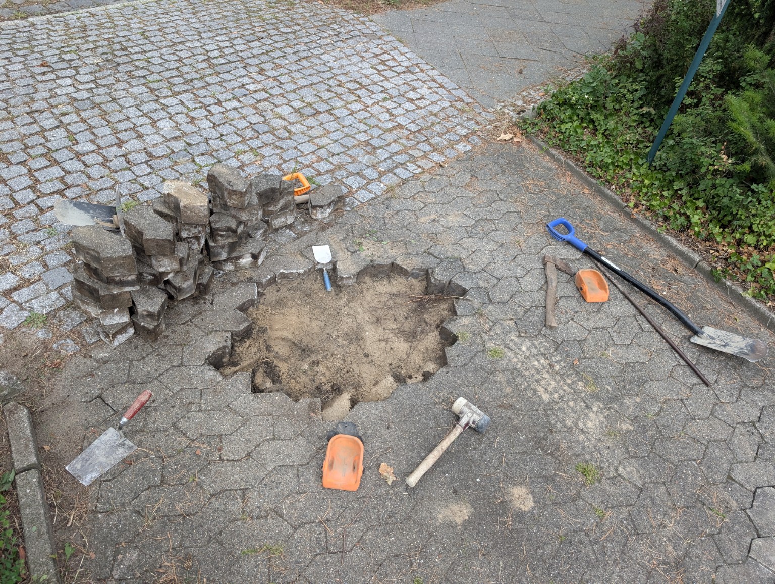 Aufgenommene Pflastersteine und freigelegter Untergrund bei einer Reparatur